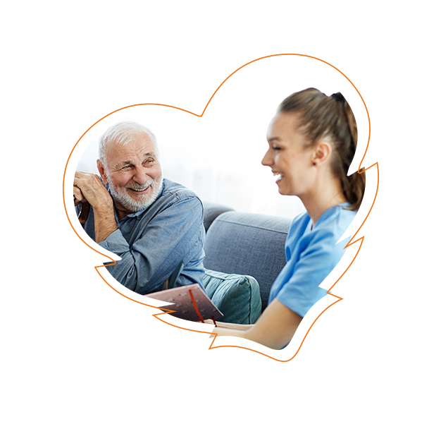 The image shows a man and a woman engaged in conversation, with the man appearing to be older and the woman younger. They are in an indoor setting, possibly a living room, with a couch visible in the background. Both individuals are smiling and seem to be enjoying their interaction.